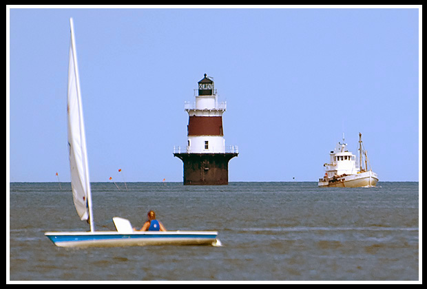 Pecks Ledge lighthouse surrounded by boats