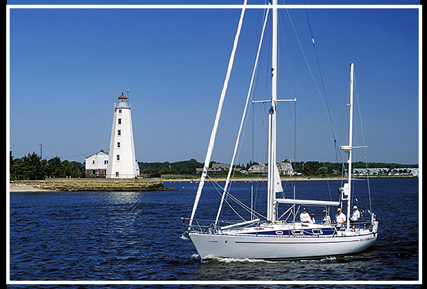 sailboat passes by Lynde Point light tower