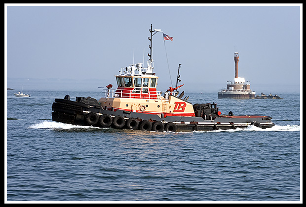 tugboat passes by deer Island lighthouse